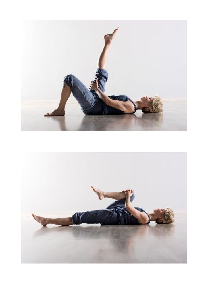 mujer acostada en el suelo estirando la pierna y flexionandola hacia el pecho.